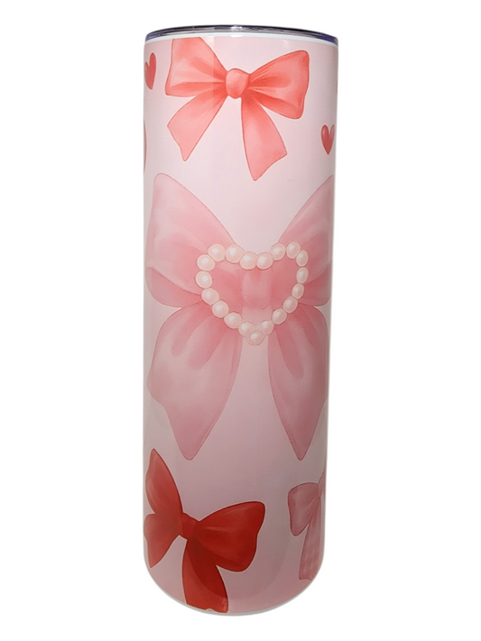 Tumbler with pink and red bows and pearl heart design on a white background