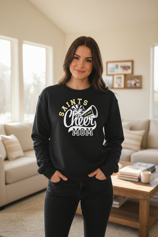 Black sweatshirt with 'Saints Cheer Mom' text on a fluffy white surface